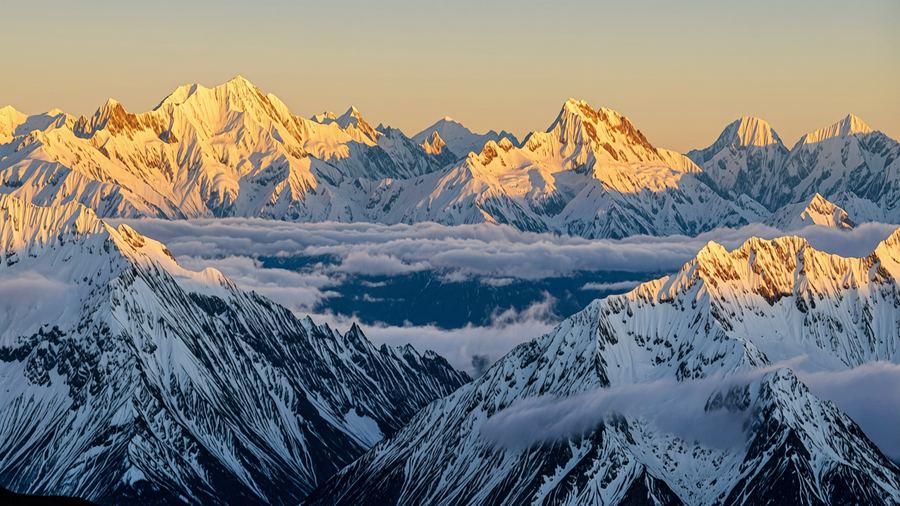 Snow-capped mountains at golden sunrise